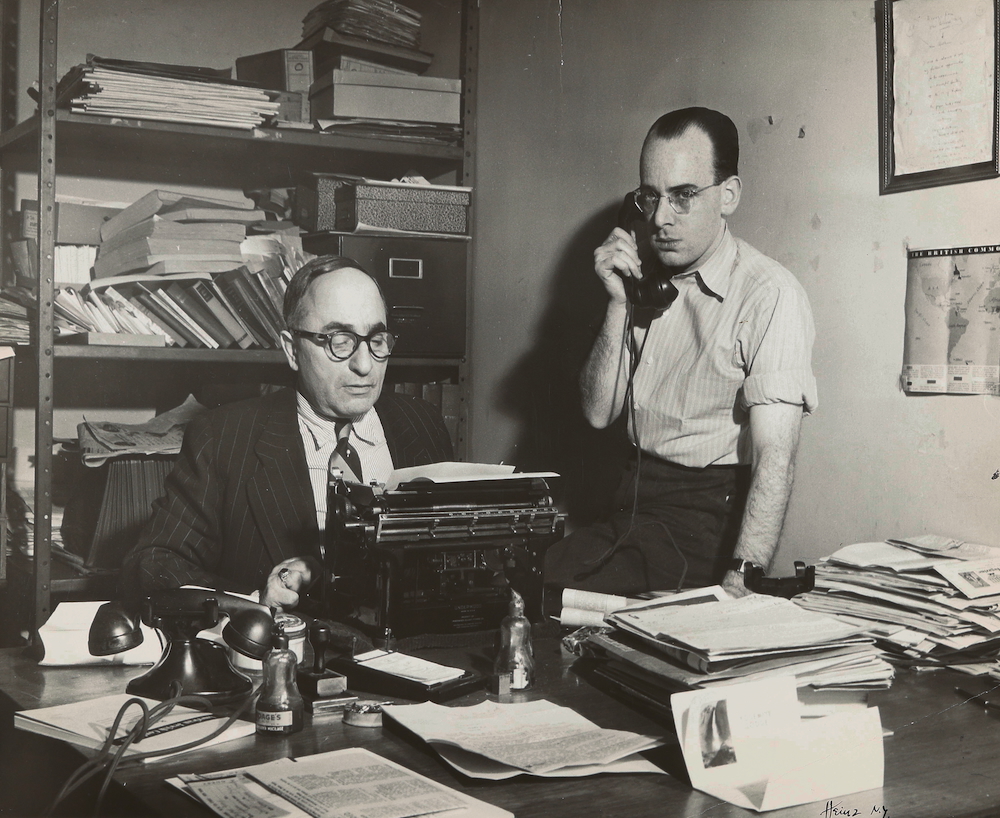 Kurt Hellmer on the telephone beside a colleague at the typewriter in the Aufbau editorial office, New York